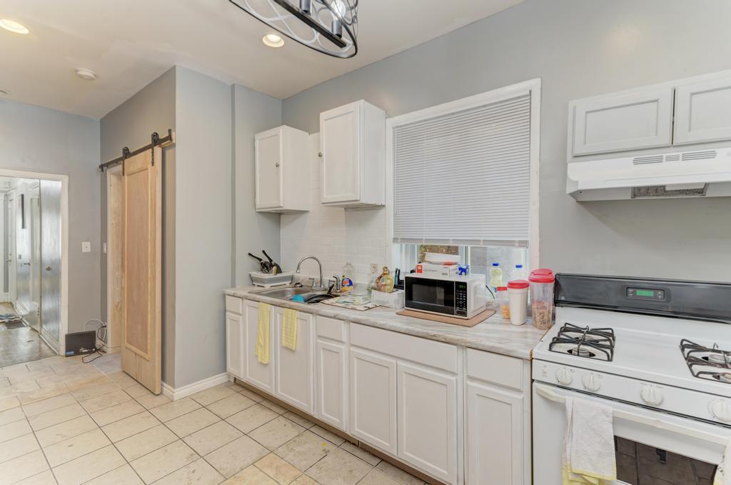 6840 South Prairie Avenue Chicago, IL 60637 - Photo 10 of 47 a kitchen with white cabinets and appliances