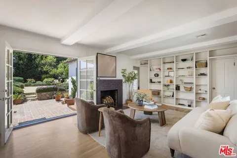 a living room with furniture a fireplace and a floor to ceiling window