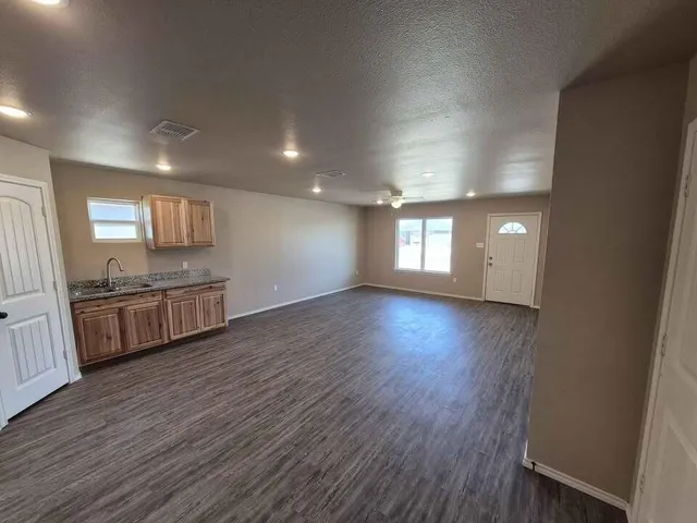 a view of a kitchen with wooden floor and a sink
