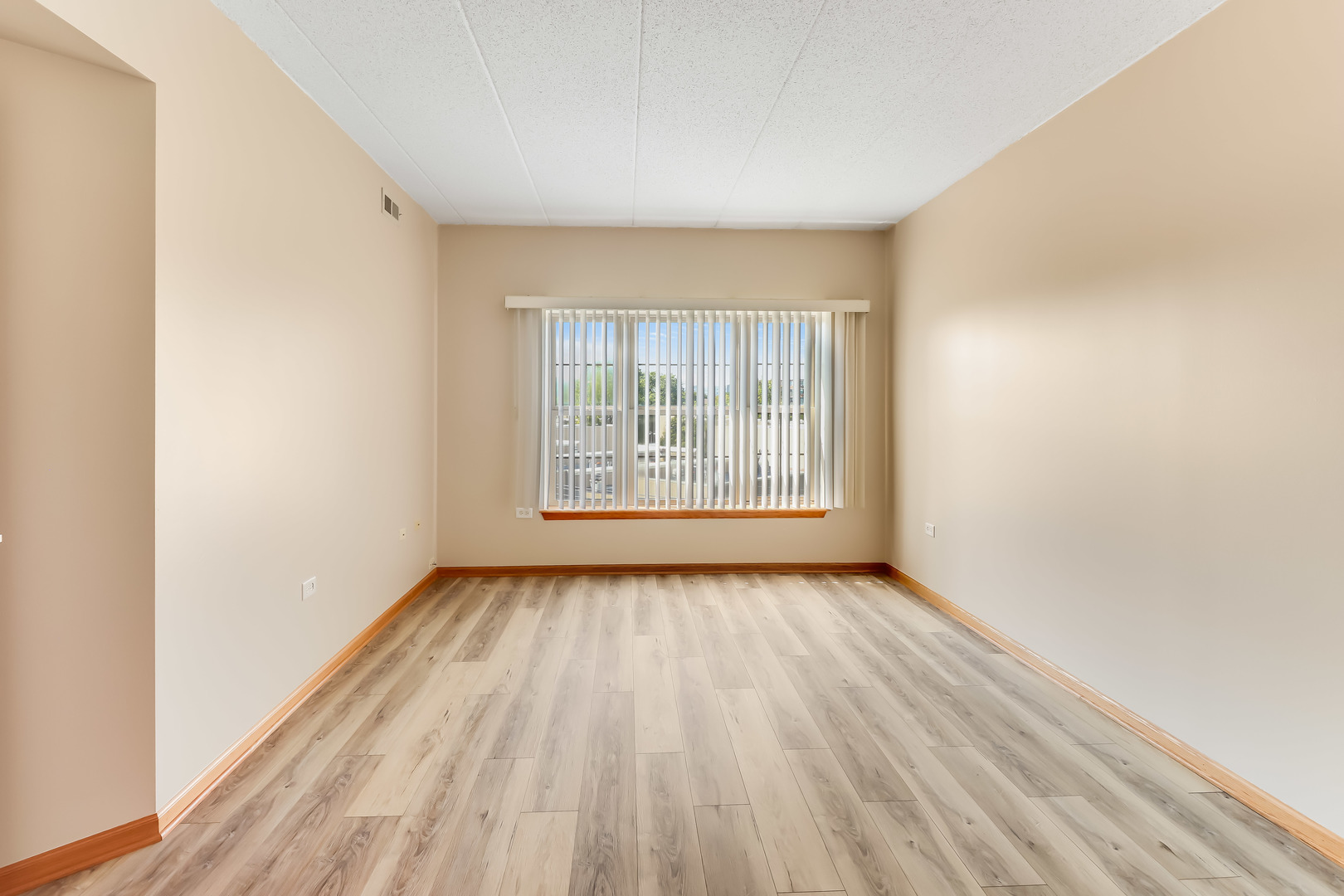 1200 South Prospect Avenue, Unit 303 Elmhurst, IL 60126 - Photo 6 of 21 an empty room with wooden floor and windows