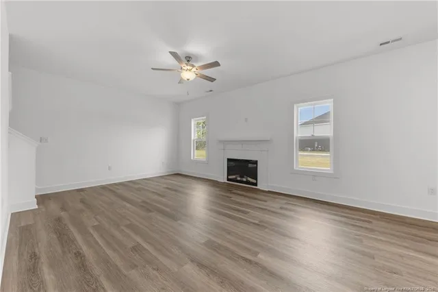 a view of main area with fireplace wooden floor and windows