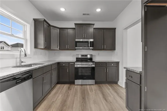 a kitchen with a sink stove and microwave