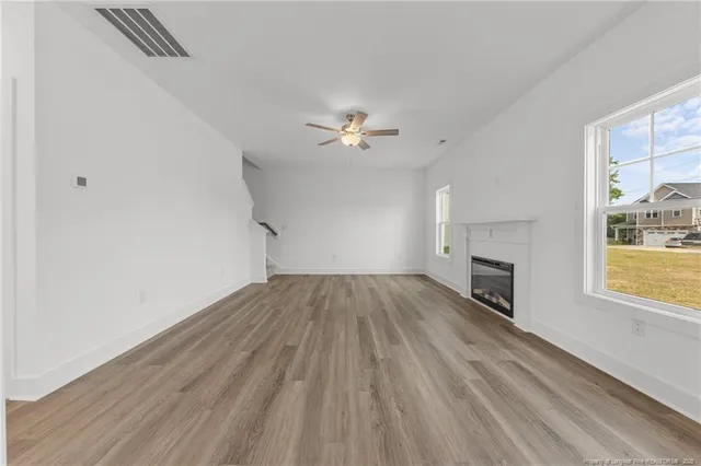 a kitchen with stainless steel appliances granite countertop a refrigerator oven a sink dishwasher and a stove with wooden floor