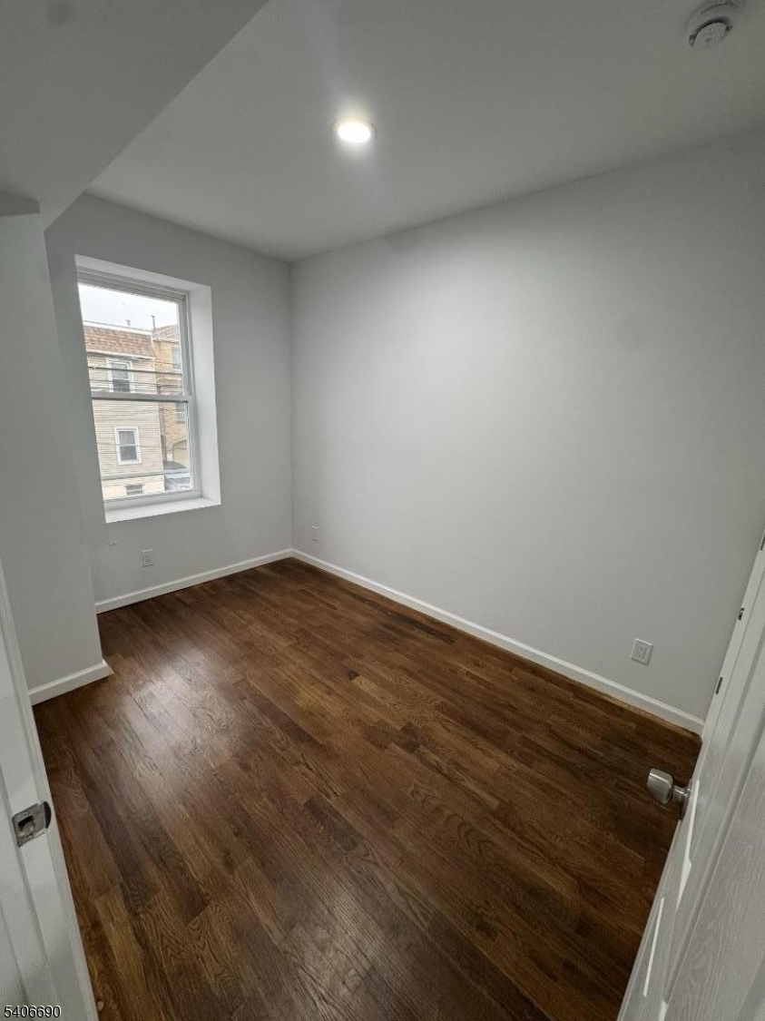 196 Malvern Street, Unit 3 Newark, NJ 07105 - Photo 12 of 16 an empty room with wooden floor and windows