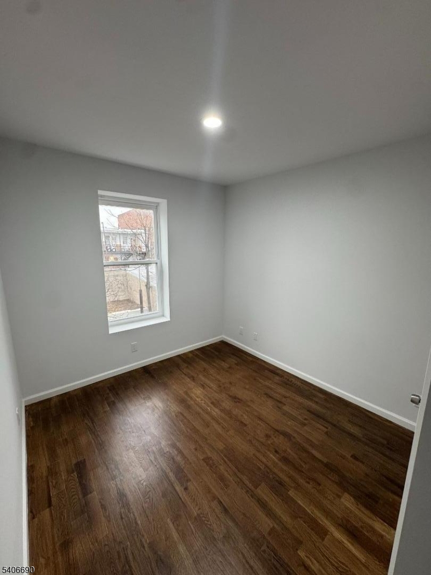 196 Malvern Street, Unit 3 Newark, NJ 07105 - Photo 13 of 16 an empty room with wooden floor and windows