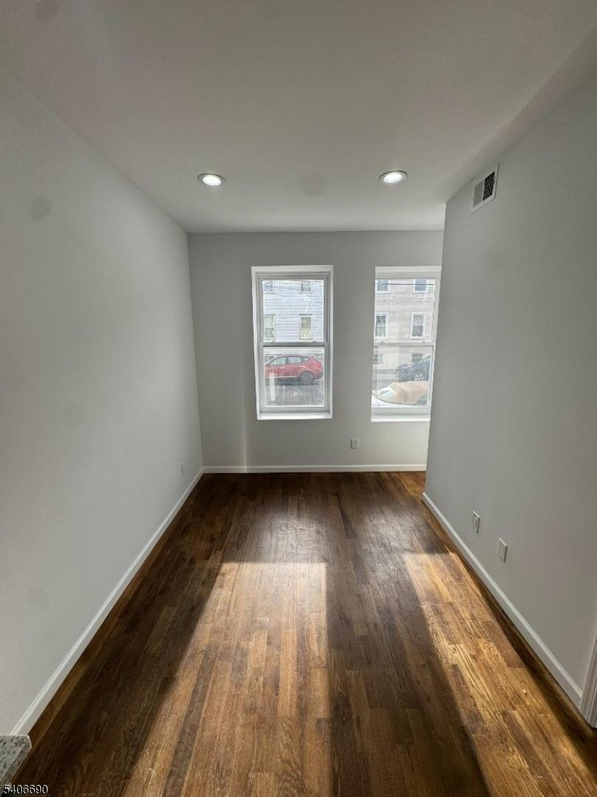 196 Malvern Street, Unit 3 Newark, NJ 07105 - Photo 5 of 16 an empty room with wooden floor and windows