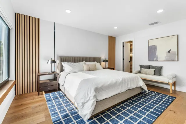 a bedroom with a large bed and a view of living room