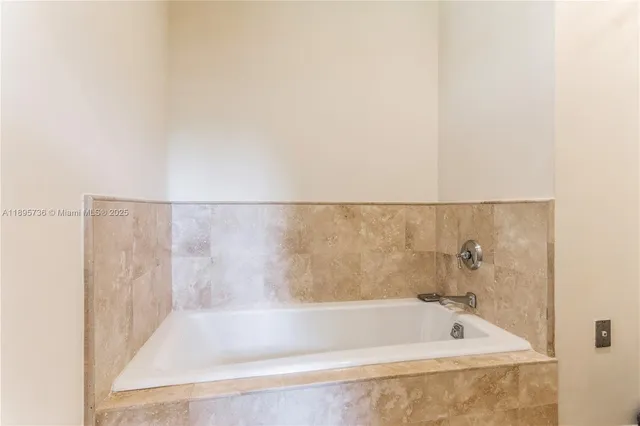 a bath tub sitting next to a white sink and vanity