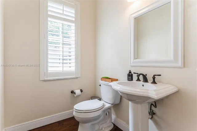 a bathroom with a sink toilet and mirror