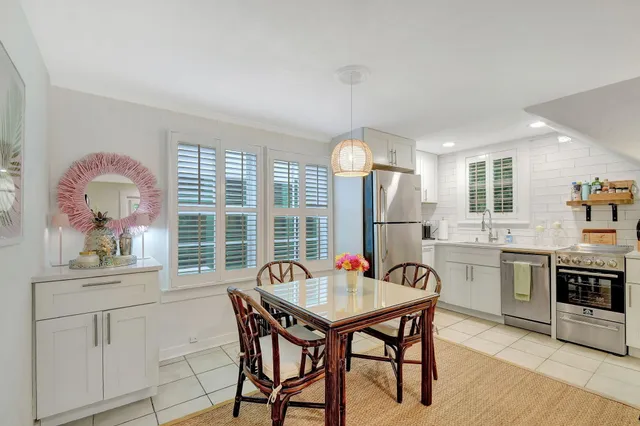 a kitchen with a table chairs sink and cabinets