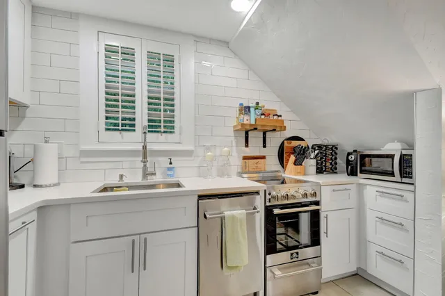 a kitchen with granite countertop white cabinets and white appliances