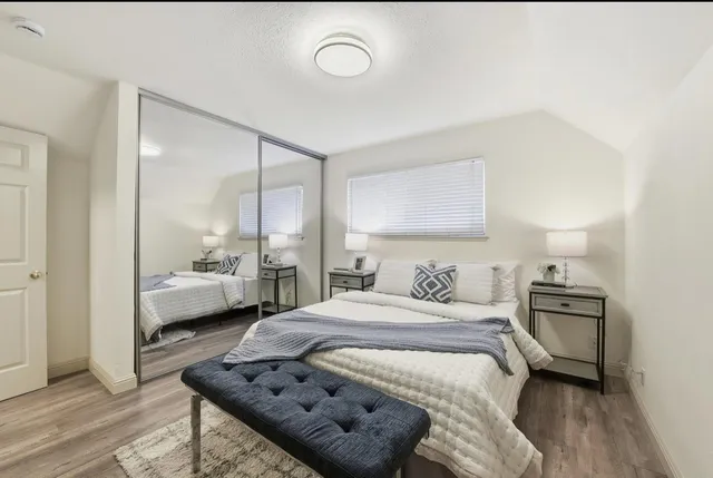 a bedroom with a bed and wooden floor