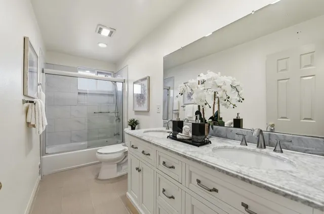 a bathroom with a granite countertop sink a toilet and shower
