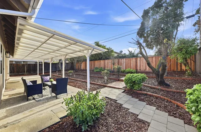 a view of a house with backyard sitting area and garden