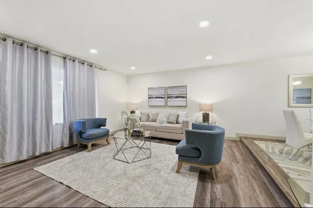 a living room with furniture and wooden floor