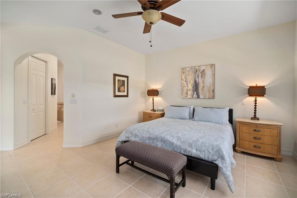 8519 Chase Preserve Drive Naples, FL 34113 - Photo 12 of 29 a bedroom with a bed a lamp and a chandelier