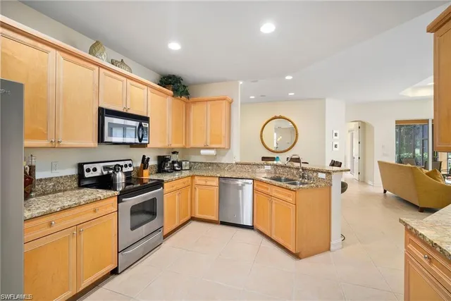 a kitchen with stainless steel appliances granite countertop a stove top oven a sink dishwasher and cabinets with wooden floor