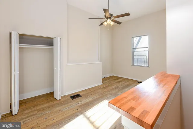 a view of a bedroom with wooden floor and closet