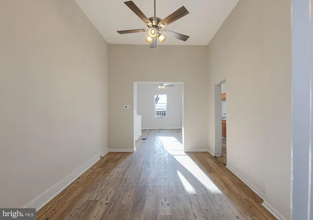 a view of a big room with wooden floor and a chandelier fan