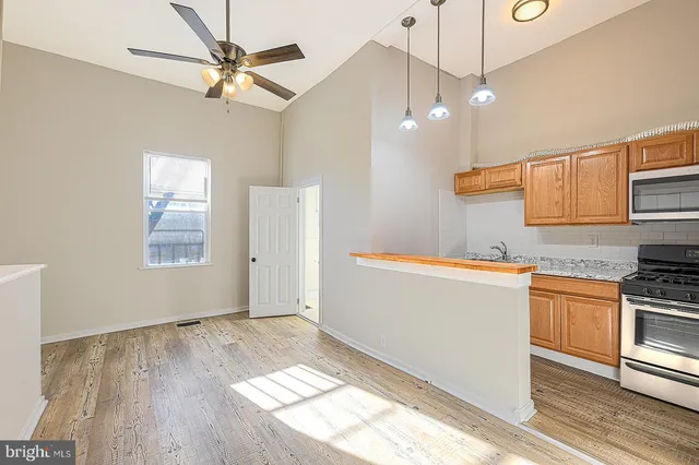 a kitchen with granite countertop wooden floors and white cabinets