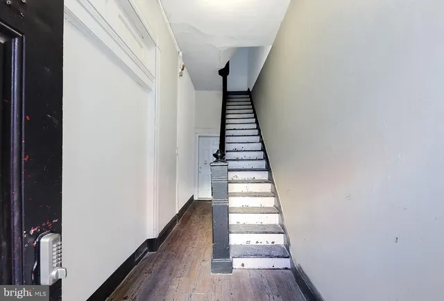 a view of a hallway with wooden floor and entryway