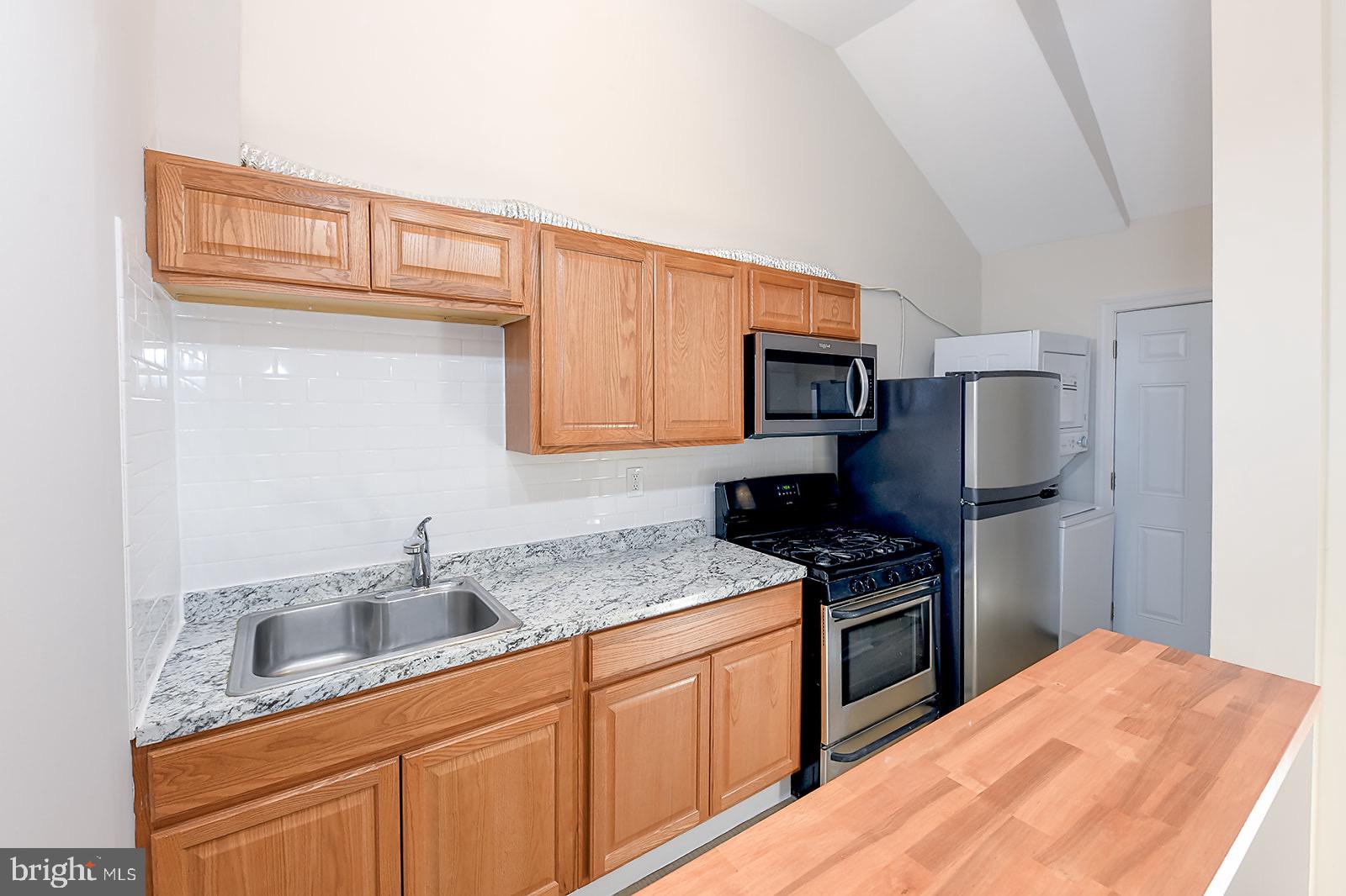 1908 McCulloh Street, Unit 1 Baltimore, MD 21217 - Photo 7 of 24 a kitchen with stainless steel appliances granite countertop a sink stove and refrigerator