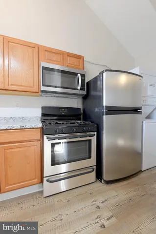 a kitchen with granite countertop white cabinets and stainless steel appliances