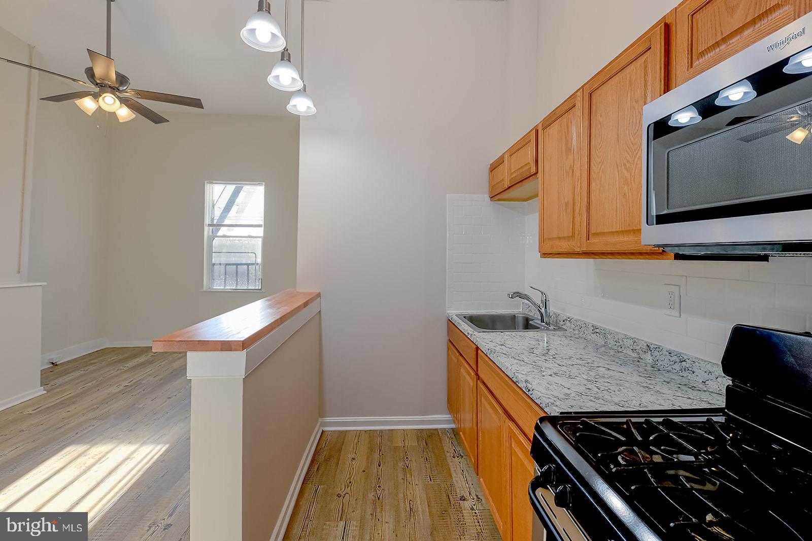 1908 McCulloh Street, Unit 1 Baltimore, MD 21217 - Photo 10 of 24 a kitchen that has a stove and a microwave