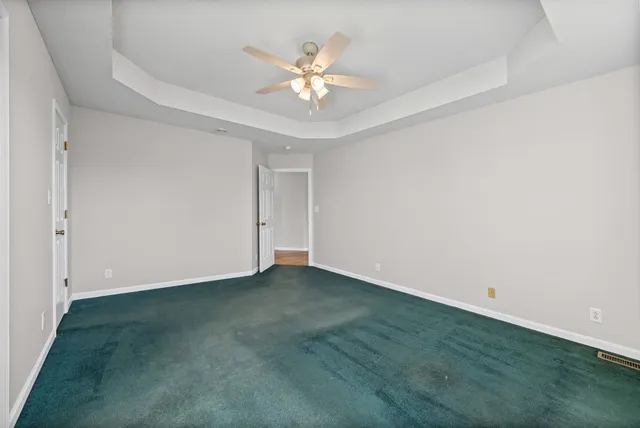 an empty room with closet and a chandelier fan