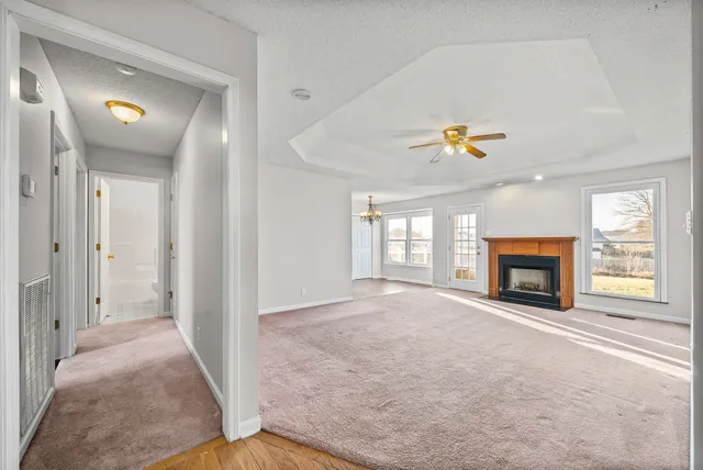a view of an empty room with a window and fireplace
