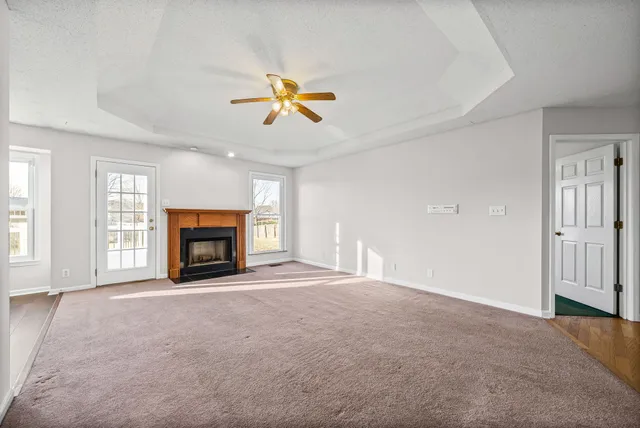 an empty room with windows and fireplace