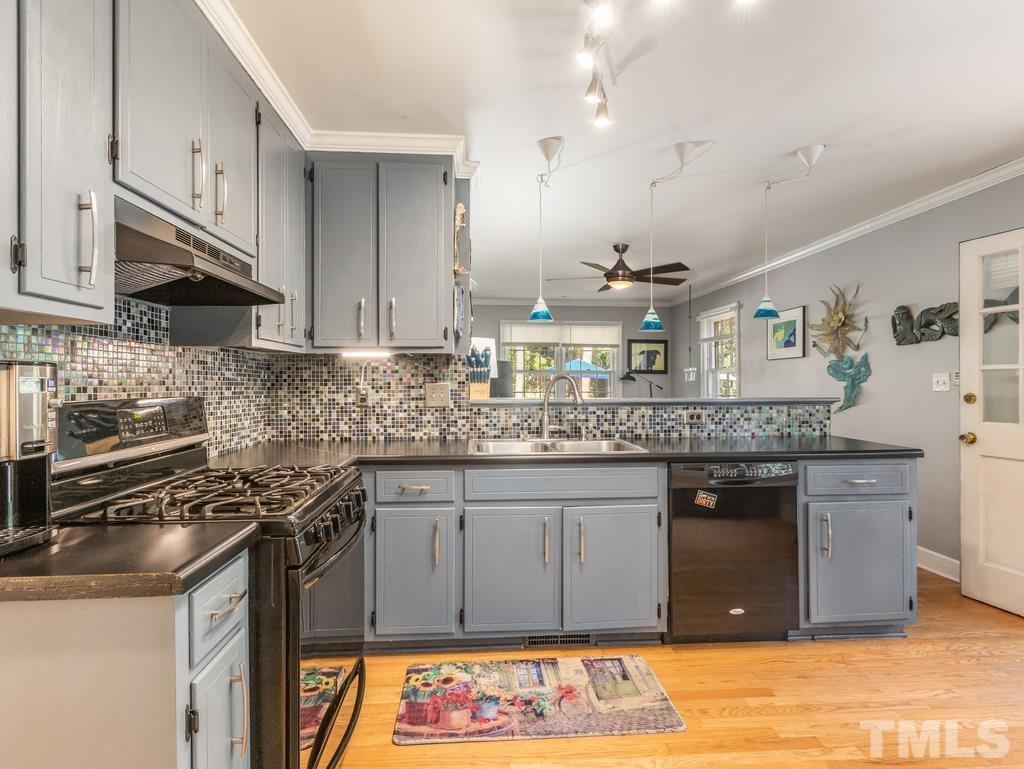 5808 Heatherbrook Circle Raleigh, NC 27612 - Photo 11 of 26 a kitchen with stainless steel appliances granite countertop a sink stove and cabinets