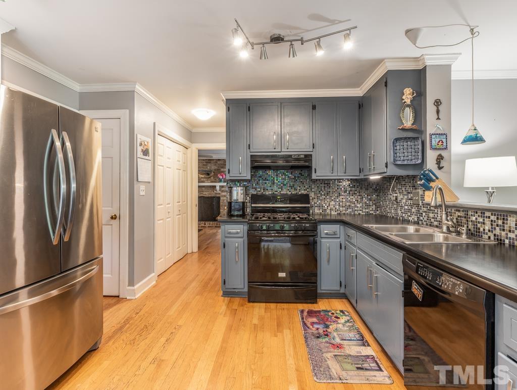 5808 Heatherbrook Circle Raleigh, NC 27612 - Photo 12 of 26 a kitchen with stainless steel appliances granite countertop a refrigerator a stove a sink and a microwave