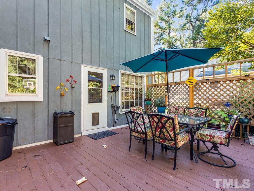 5808 Heatherbrook Circle Raleigh, NC 27612 - Photo 23 of 26 a view of a roof deck with table and chairs under an umbrella