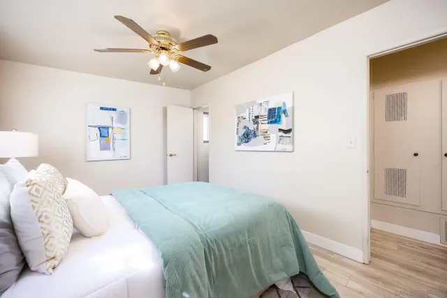 a bedroom with a large bed and a chandelier