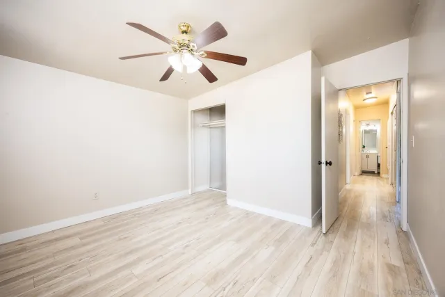 a bedroom with a large bed a chandelier and a painting on the wall