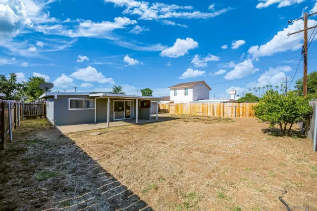 a view of a house with backyard and sitting area