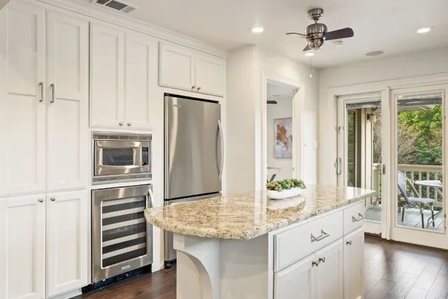 a kitchen with stainless steel appliances granite countertop a refrigerator and a stove top oven