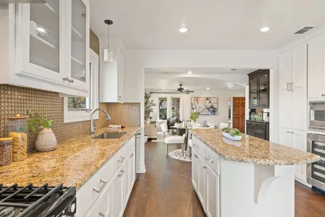 a kitchen with counter top space sink stove and cabinets