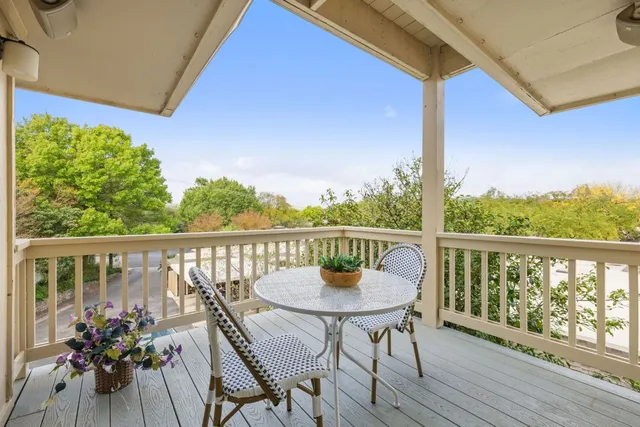 a view of a balcony with wooden chairs