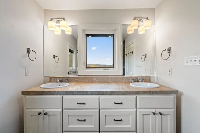 a bathroom with a granite countertop sink and a mirror