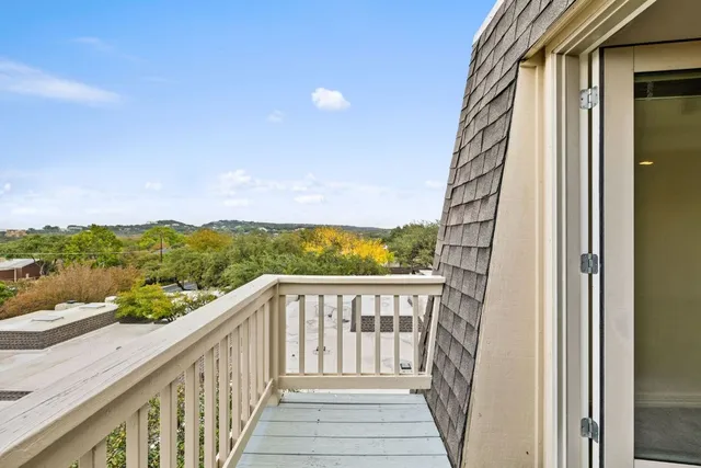 a view of a balcony with wooden floor and fence
