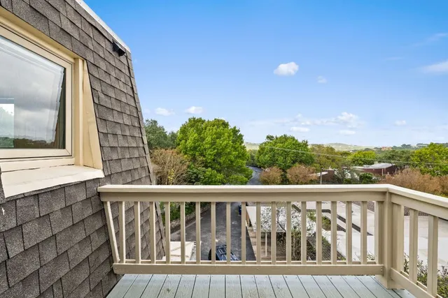 a view of a balcony with wooden floor and fence