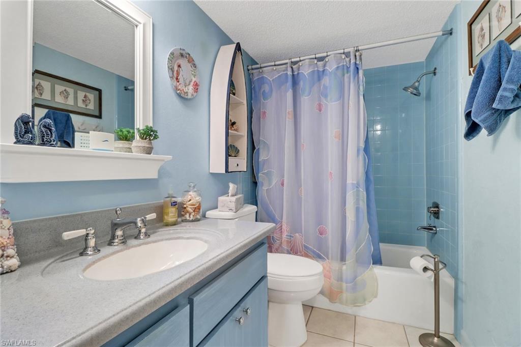 300 Valley Stream Drive, Unit A4 Naples, FL 34113 - Photo 17 of 25 a bathroom with a granite countertop sink toilet a mirror a vanity and shower