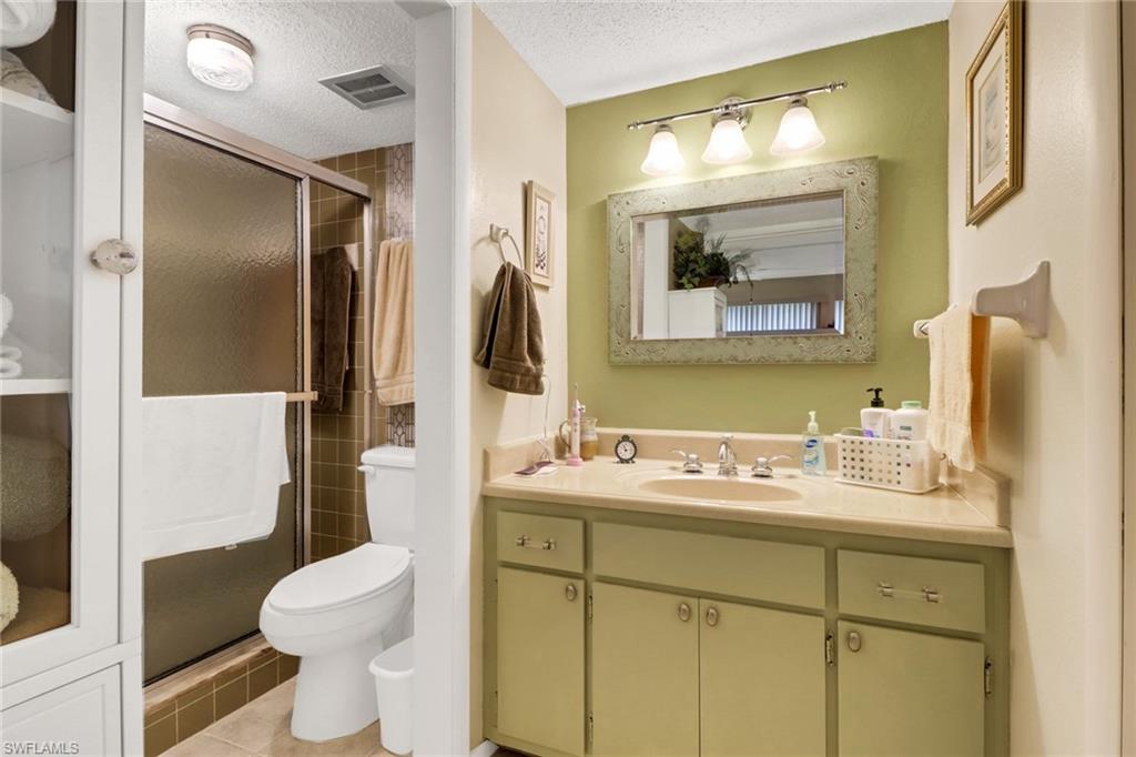 300 Valley Stream Drive, Unit A4 Naples, FL 34113 - Photo 18 of 25 a bathroom with a toilet sink and mirror