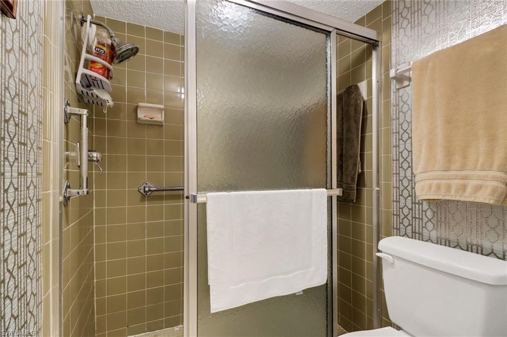 300 Valley Stream Drive, Unit A4 Naples, FL 34113 - Photo 19 of 25 a bathroom with a shower and a toilet