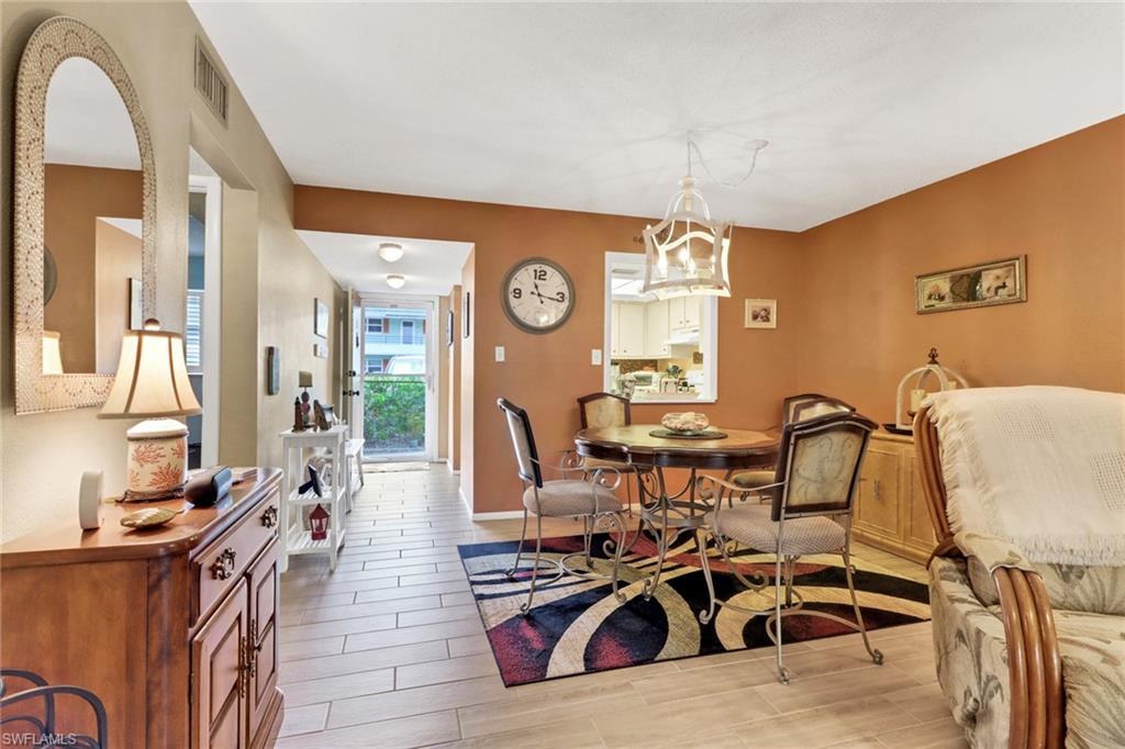 300 Valley Stream Drive, Unit A4 Naples, FL 34113 - Photo 4 of 25 a living room with furniture a clock and a large window