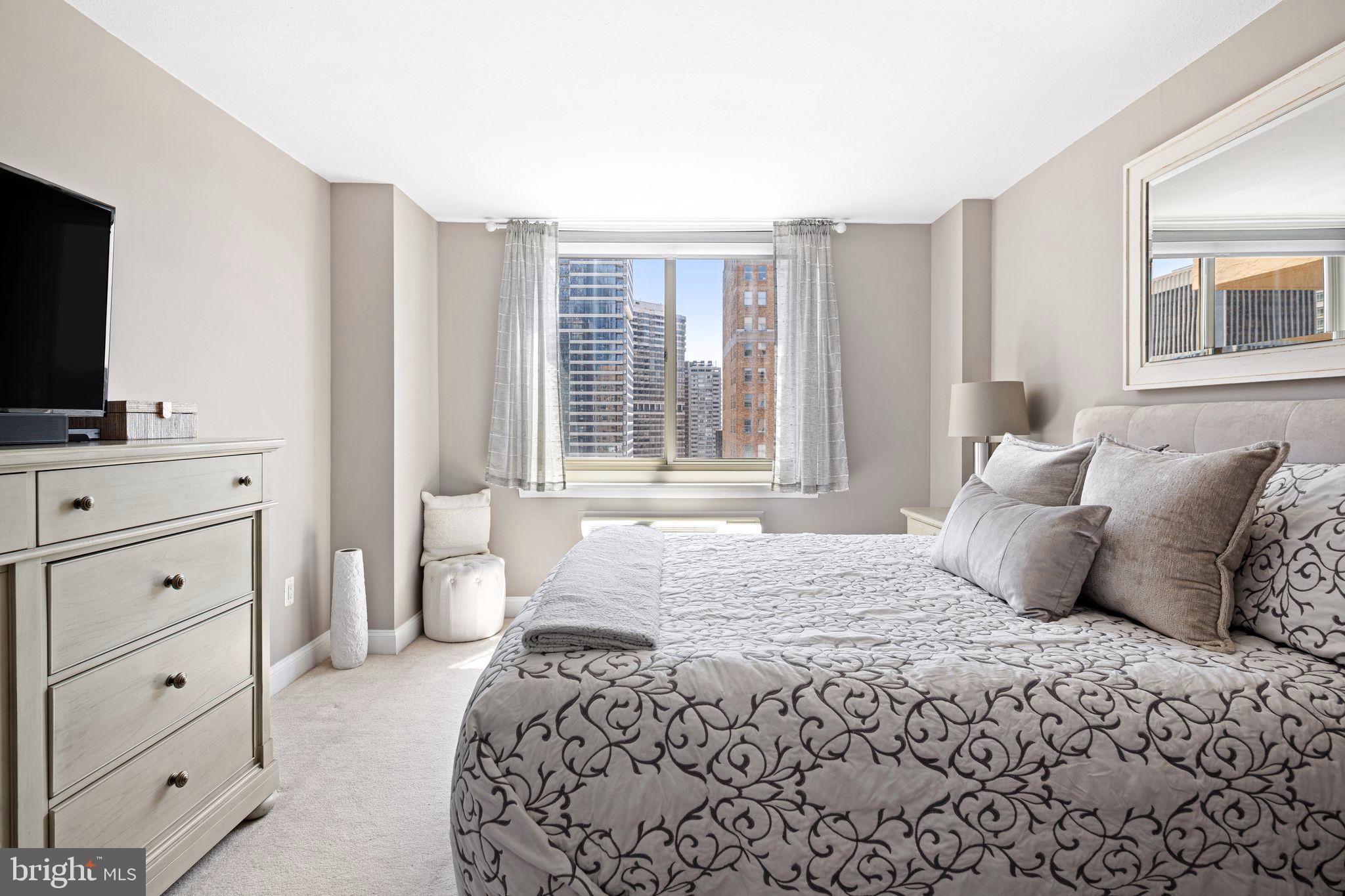 1919 Chestnut Street, Unit 2016 Philadelphia, PA 19103 - Photo 25 of 34 a bedroom with a large bed and a flat screen tv