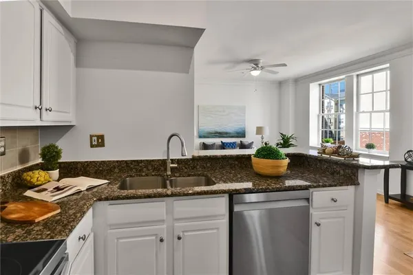 a kitchen with granite countertop a sink a stove and cabinets