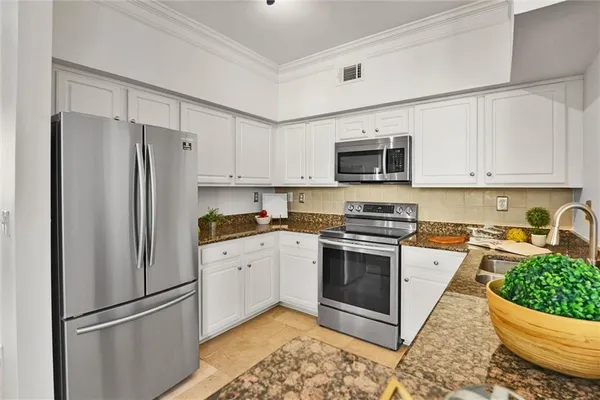 a kitchen with stainless steel appliances granite countertop a refrigerator stove a sink and a microwave